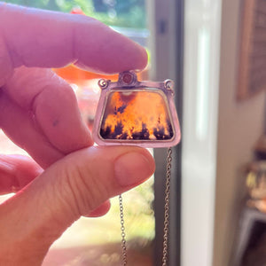 May include: A silver pendant with a chain. The pendant is a rectangular shape with a beveled edge and a clear glass window that shows a slice of agate with brown, orange, and white colors.