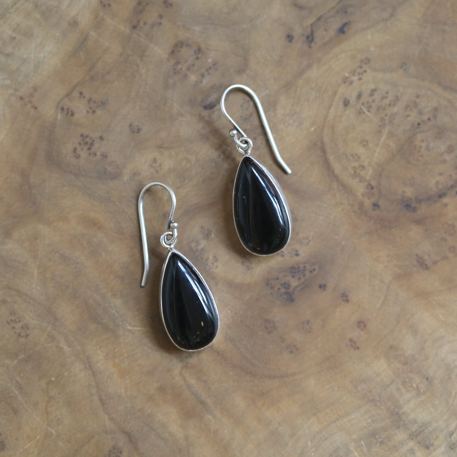 May include: A pair of silver teardrop earrings with black gemstone accents