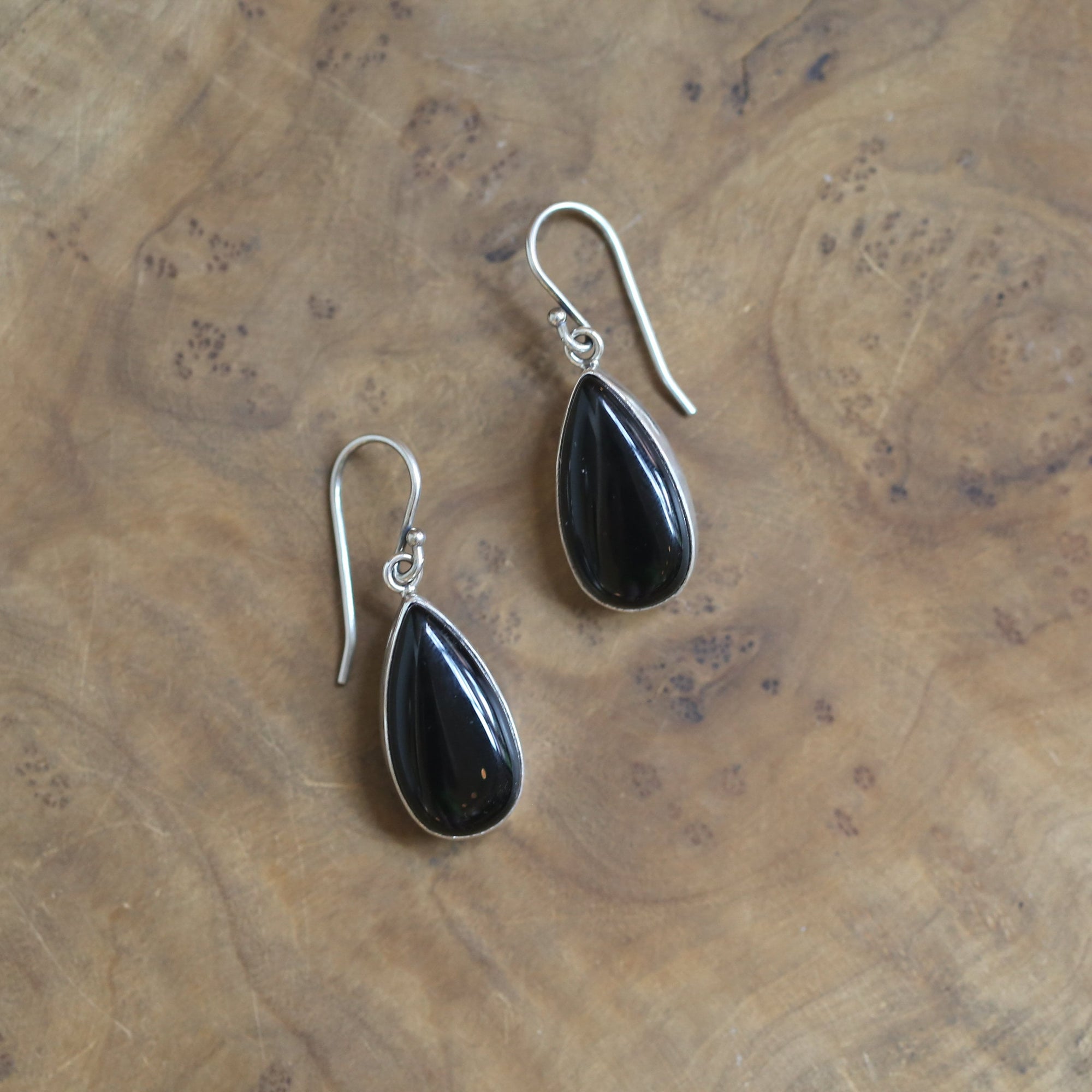 May include: A pair of silver teardrop earrings with black gemstone accents