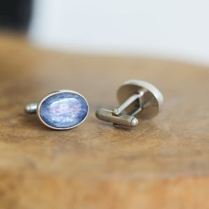 May include: A pair of silver cufflinks with oval blue gemstone insets.