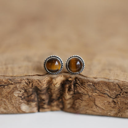 May include: Two silver stud earrings with brown tiger's eye gemstones