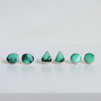 May include: A set of five turquoise earrings in different shapes, including round and triangular, with silver settings.