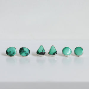 May include: A set of five turquoise earrings in different shapes, including round and triangular, with silver settings.