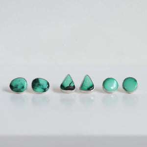 May include: A set of five turquoise earrings in different shapes, including round and triangular, with silver settings.